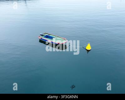 Perspective en hauteur d'un seul bateau ancré dans des eaux calmes pendant une journée tranquille Banque D'Images