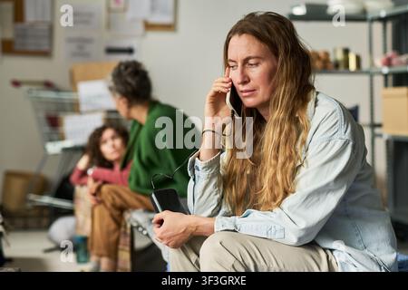 Femme adulte appelant le soutien en cas de crise lors d'une séance de conseil familial Banque D'Images