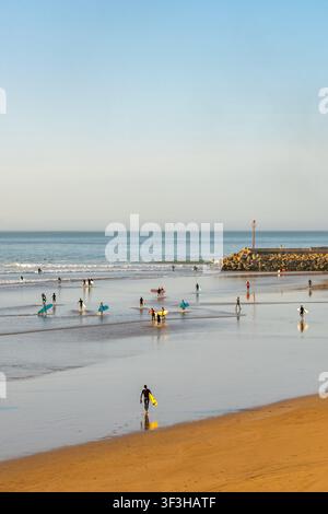 Surfeurs marchant sur le sable et profitant des vagues à Imsouane au Maroc Banque D'Images