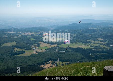 Parapentes au-dessus de la vallée verte depuis une crête montagneuse avec une vue aérienne panoramique de la campagne Banque D'Images