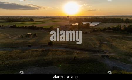 Vue aérienne de la réserve naturelle spéciale Zasavica au coucher du soleil, mettant en scène des champs agricoles, des serres et un paysage rural à Zasavica, Vojvodina, Serbie Banque D'Images