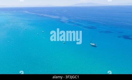 Plage de Possidi, Grèce 11 juillet 2026. Vue aérienne d'une mer turquoise avec un voilier et plusieurs petits bateaux près de la plage de Possidi en Grèce sous un ciel clair Banque D'Images