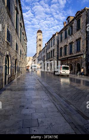 La longue étendue droite de la célèbre rue piétonne Stradun de Dubrovnik s'étend vers le clocher du monastère franciscain dans la lumière matinale Banque D'Images