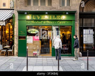 Des gens devant la Juveniles Wine Bar, une wine bar et cave à manger (boutique/bistro de vins) populaire située rue de Richelieu à Paris, France Banque D'Images