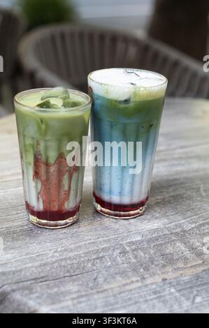 Latte glacé au matcha et boissons stratifiées au matcha bleu sur une table en bois rustique Banque D'Images