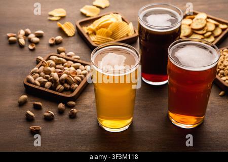 Table pour la compagnie d'amis. Des collations croustillantes et différents types de bière dans des verres Banque D'Images