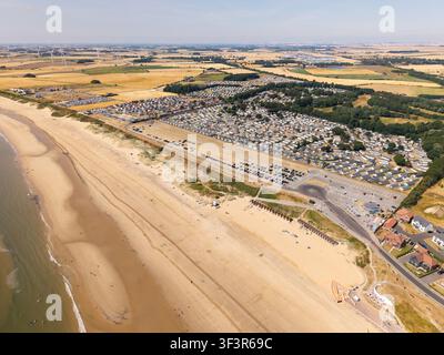 Paysage panoramique aérien grand angle vu de haut avec la côte Est du Yorkshire dans la zone de The South Beach de Bridlington avec un parc de caravanes sur une plage Banque D'Images