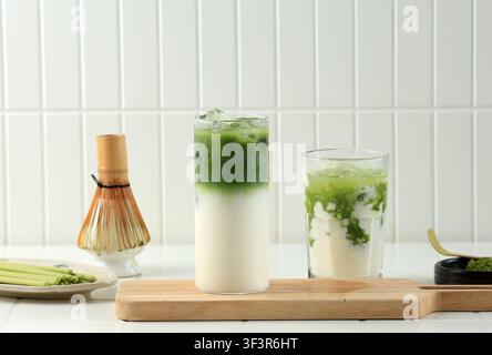 Latte Matcha glacé dans un verre sur fond blanc. Boisson rafraîchissante au thé vert avec du lait dans un verre transparent pour concepts de boissons Banque D'Images