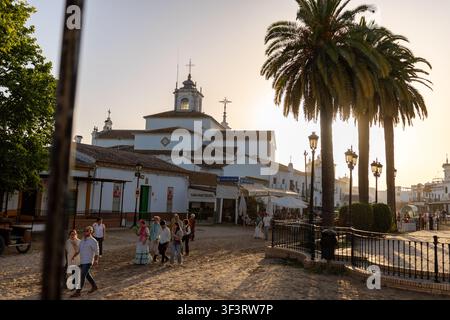 Pèlerins de la Romería de El Rocío à cheval en tenue andalouse traditionnelle traje corto et robes flamenco rassemblés devant l’Ermita de El Rocío blanche Banque D'Images