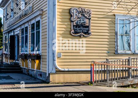 Le panneau en bois du Rudder’s Seafood Restaurant & Brew Pub est accroché à la façade jaune de Water Street à Yarmouth, en Nouvelle-Écosse, au Canada. La brasserie sur place, avec sa bouilloire de brassage alimentée par gravité, est la seule brasserie-restaurant dans la région de Yarmouth & Acadian Shores Banque D'Images