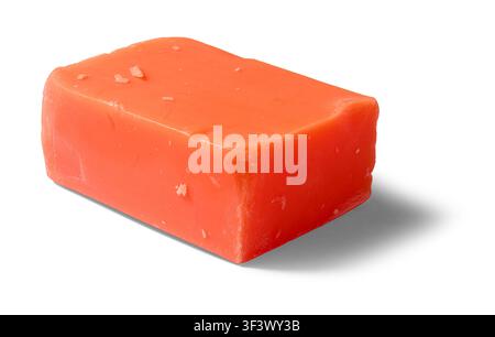 savon orange solide isolé sur fond blanc, bloc rectangulaire d'un produit cosmétique de nettoyage fait main avec surface texturée Banque D'Images