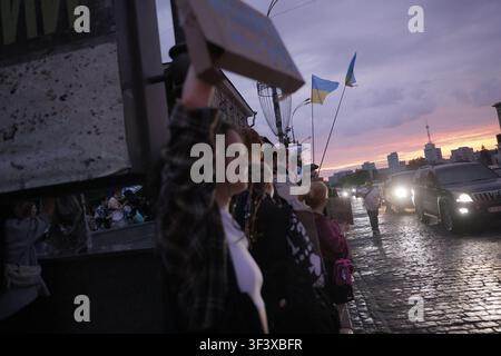 Kharkiv, Ukraine. 25 juillet 2026. Des manifestants tenant des drapeaux ukrainiens se rassemblent sur une rue mouillée lors d'une manifestation contre la décision du président ukrainien Volodymyr Zelenskiy de remplacer Fedorov en tant que ministre de la Défense, alors que le soleil se couche sur le paysage urbain de Kharkiv, en Ukraine, le 25 juillet 2026. La manifestation du soir a attiré les résidents dans les rues pour exprimer leur opposition au remaniement gouvernemental. Plusieurs véhicules avec les phares allumés bordent le trottoir mouillé tandis que des foules se rassemblent le long du front de mer. Photo de Yevhen Titov/ABACAPRESS.COM Crédit : Abaca Press/Alamy Live News Banque D'Images