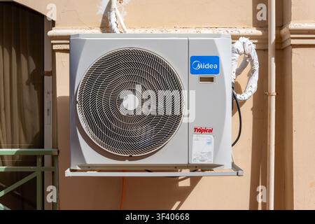 Unité de condenseur de climatisation Midea avec une étiquette de marque 'Tropical', montée sur un mur résidentiel en Égypte. Banque D'Images