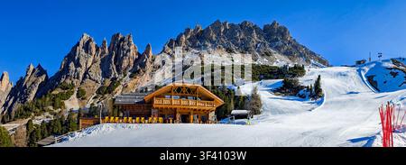 Scène panoramique de station de ski alpin sur la Sella Ronda entre Alta Badia et Val Gardena dans les Dolomites, avec chalet de montagne, pistes de ski préparées et dragon Banque D'Images