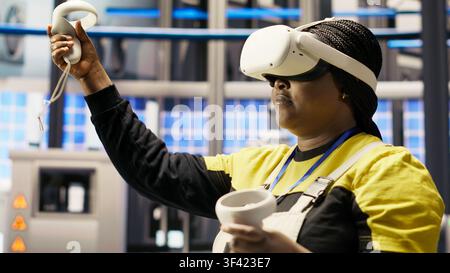 Expert en usine intelligente photovoltaïque utilisant la technologie VR pour gérer les systèmes d'automatisation. Technicien d'usine Industrie 4.0 en panneaux solaires utilisant un équipement de réalité virtuelle pour évaluer les équipements, caméra B Banque D'Images