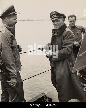À bord d'un LST piloté par la Garde côtière, le lieutenant-colonel nazi Hans Franz Muller, à droite, décoré à quatre reprises pour ses exploits de guerre, converse avec l'enseigne de la Garde côtière Axel B. Carlson alors que l'Allemand est transporté à travers la Manche pour être interné en Angleterre. Muller a été capturé lors de la bataille de Saint-Mère-Église. Il porte la Croix de fer et d'autres médailles, ainsi qu'un ruban pour sa participation à la campagne de Russie. La résidence de l'enseigne Carlson est au 16 Church Street, Manasquan, New Jersey, et les deux hommes échangent brièvement sur le pont du navire. Banque D'Images