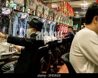 Des gens jouant à des machines à pachinko à l'intérieur d'un salon de pachinko à Nishi-Shinjuku, Shinjuku, Tokyo, Japon Banque D'Images