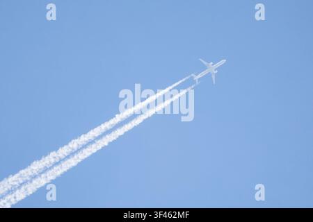 Avion à réaction laissant des traînées de vapeur dans un ciel bleu, Banque D'Images