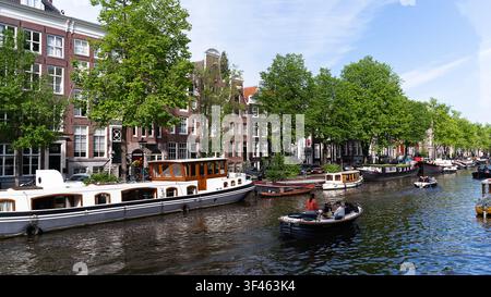 Canal traditionnel bordé de maisons historiques et de bateaux au centre d'Amsterdam, Pays-Bas Banque D'Images