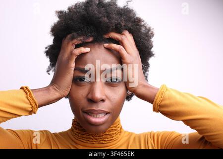 Jeune femme noire stressée tenant sa tête de frustration Banque D'Images