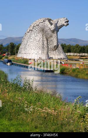 Visiteurs aux Kelpies, les sculptures emblématiques de têtes de cheval de 30 mètres de haut à The Helix à Falkirk, en Écosse, par une journée d'été claire. Banque D'Images