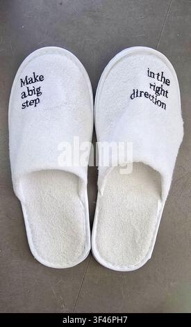 Chaussures blanches avec texte de motivation sur un sol gris Banque D'Images