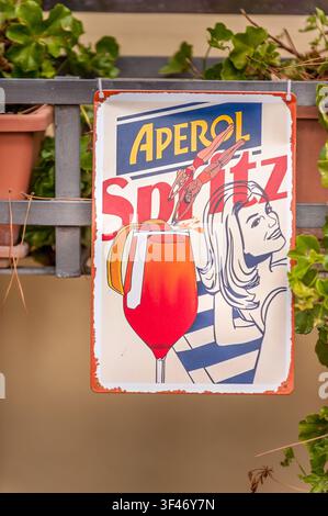 Panneau publicitaire en émail de style vintage pour l'Aperol Spritz devant un bar dans le centre médiéval de Gubbio, Ombrie, Italie Banque D'Images