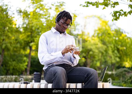 Homme comptant de l'argent à l'extérieur Banque D'Images
