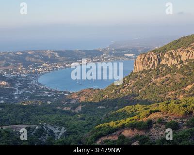 Lumière de l'heure dorée sur la baie de Kefalos avec des yachts ancrés et le village de Kamari sur la côte égéenne de l'île de Kos, Dodecanèse, Grèce Banque D'Images