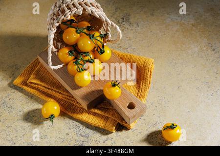 Vue du dessus de tomates cerises jaunes anciennes dans un panier sur du bois Banque D'Images