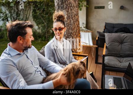 Homme et femme profitant d'une conversation en plein air avec un petit chien Banque D'Images