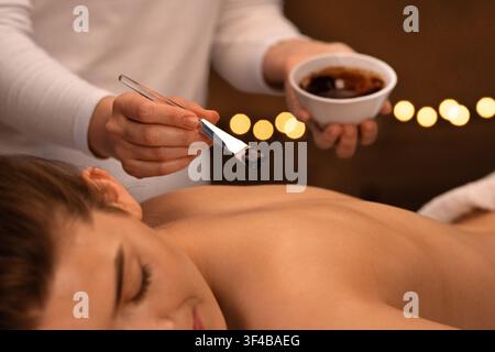 Femme thérapeute appliquant un masque exfoliant sur le corps de la femme Banque D'Images