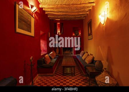 Intérieur meublé de style oriental avec plafond en bois traditionnel, avec des sièges dans un riad, les murs sont en plâtre de chaux Tadelakt, Marrakech, Maghreb Banque D'Images
