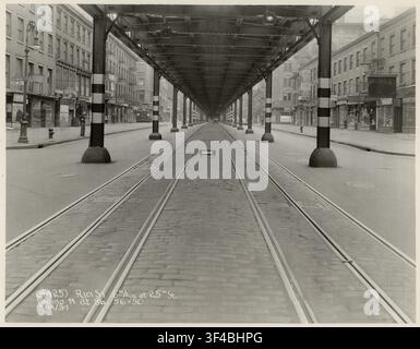 New York, Manhattan, Elevated RR, 6th Avenue, 25th Street, Nord, Trafic, États-Unis, Rue de ville déserte traversée par des voies de tramway et bordée de bâtiments Banque D'Images