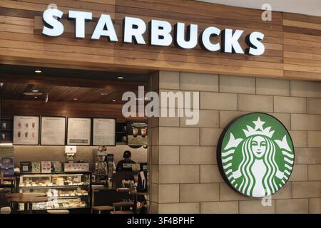Penang, Malaisie – 16 octobre 2025 : Un café de marque Starbucks arbore le logo vert en évidence sur le mur avec les éléments du menu visibles o Banque D'Images