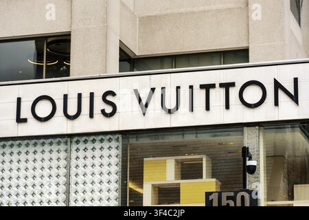 L'extérieur d'une boutique Louis Vuitton à Toronto, avec la signalisation emblématique de la marque au-dessus de grandes vitrines et des détails architecturaux modernes Banque D'Images
