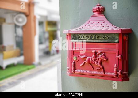 Gros plan de la boîte aux lettres décorative rouge avec le signe de lettres monté sur le mur avec une faible profondeur de champ Banque D'Images