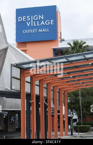 Penang, Malaisie - 16 octobre 2025 : Design Village Outlet Mall est clairement indiqué par une enseigne bleu vif contre une structure orange moderne Banque D'Images