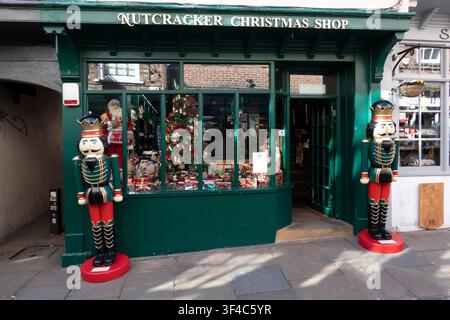 La vitrine festive verte du The Nutcracker Christmas Shop à York, flanquée de deux grandes statues de soldats casse-noisettes avec une vitrine, Royaume-Uni. Banque D'Images