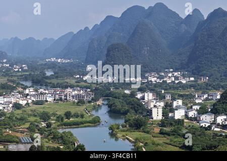 Vue aérienne de la rivière Li serpentant à travers les montagnes karstiques et le village rural du comté de Yangshuo à Guilin, Guangxi, Chine. Banque D'Images
