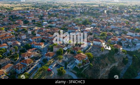 Une vue aérienne d'Afitos sur Kassandra, montrant un amas dense de maisons aux toits en terre cuite et aux rues sinueuses, entouré d'arbres et d'un fi ouvert Banque D'Images