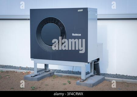 Unité extérieure d'une pompe à chaleur air-eau moderne fabriquée par Buderus installée sur une fondation à l'extérieur d'un bâtiment. Banque D'Images