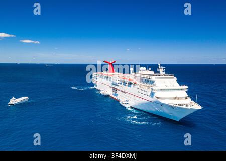 Les îles Berry, Les Bahamas – 02 mai 2020 : Vue aérienne d’un grand navire de croisière naviguant dans les eaux bleu profond de l’océan Atlantique avec de petites supp Banque D'Images