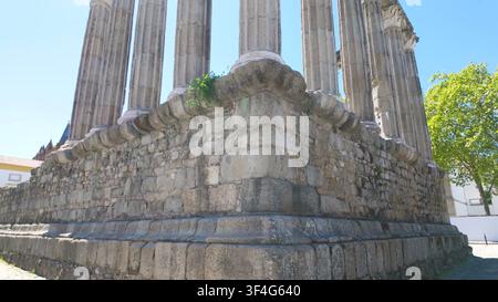 ÉVORA, PORTUGAL - 15 MAI 2024 : Une perspective basse des colonnes en granit et des fondations en pierre ancienne du temple romain d'Évora, Portugal. Banque D'Images