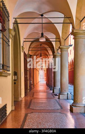 Bologne, Italie - Mai 2026 : Vue en perspective symétrique d'une longue arcade de portique historique avec des colonnes classiques et un plafond en voûte en croix Banque D'Images