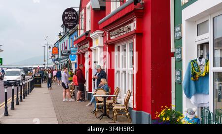 Vitrines colorées, pubs et vie de quartier le long du front de mer de Dingle, y compris le Dingle Bay Hotel et Paudie's Bar, comté de Kerry, Irlande. Banque D'Images