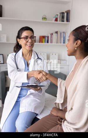 Médecin joyeux et confiant en blouse de laboratoire serrant la main d'un patient Banque D'Images