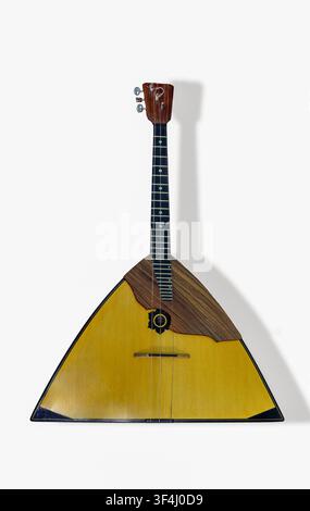 Balalaïka. Un instrument à cordes distinctif avec un corps triangulaire et un long cou repose sur une surface plane, mettant en valeur son design unique et son artisanat Banque D'Images