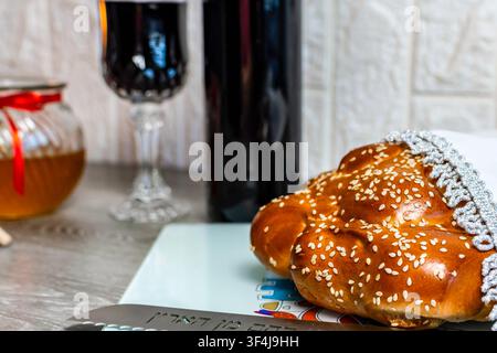 Pain challah, miel et vin sur une table, représentant les traditions des fêtes juives Banque D'Images