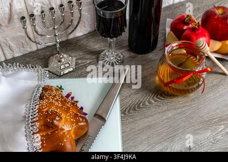 Symboles juifs du nouvel an avec des pommes, du miel, de la challah et du vin pour une célébration traditionnelle des fêtes Banque D'Images